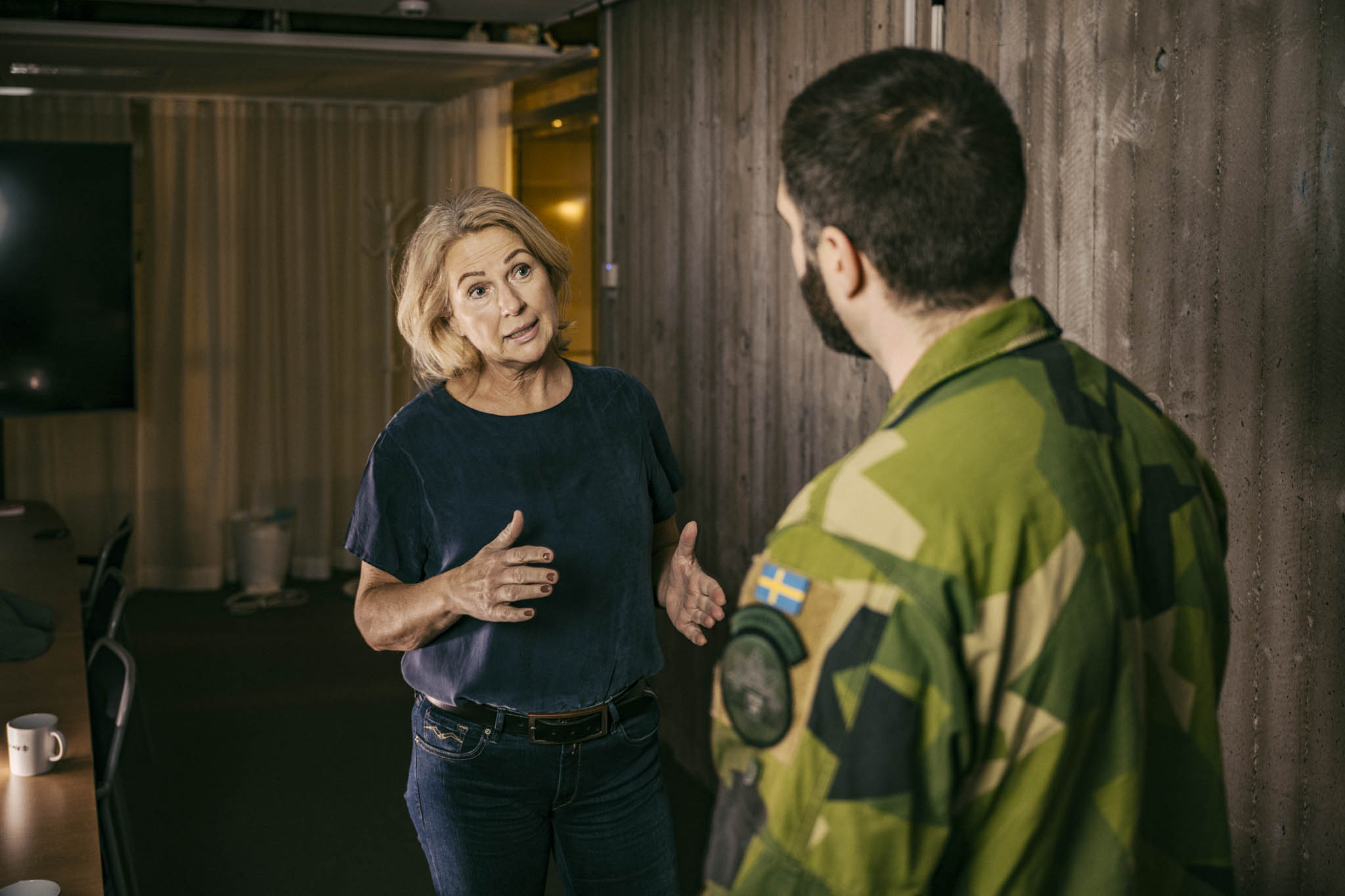 Medarbetare från FMV förklarar något för en militär i kontorsmiljö