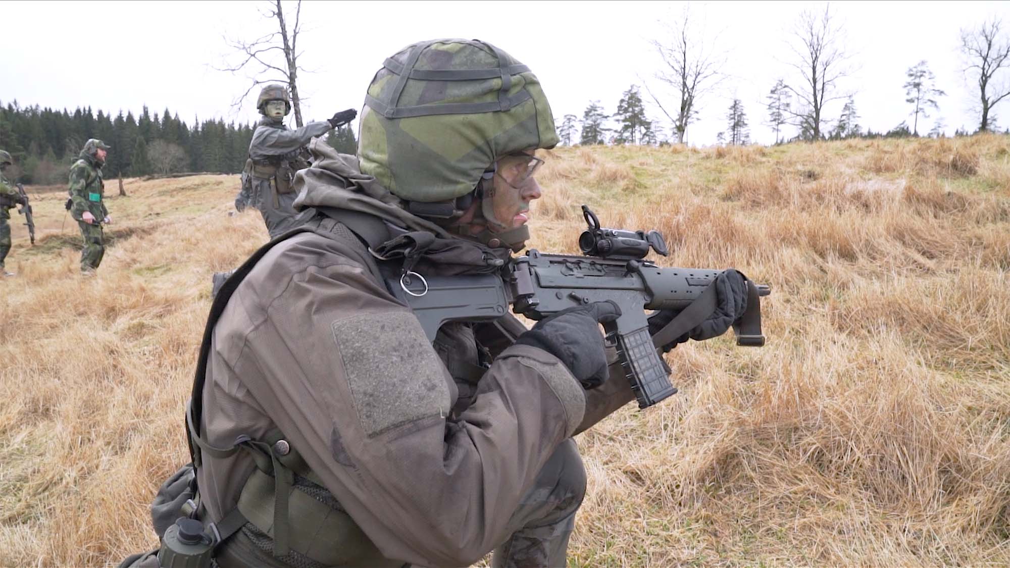 Soldater i övning på ett fält i uniform