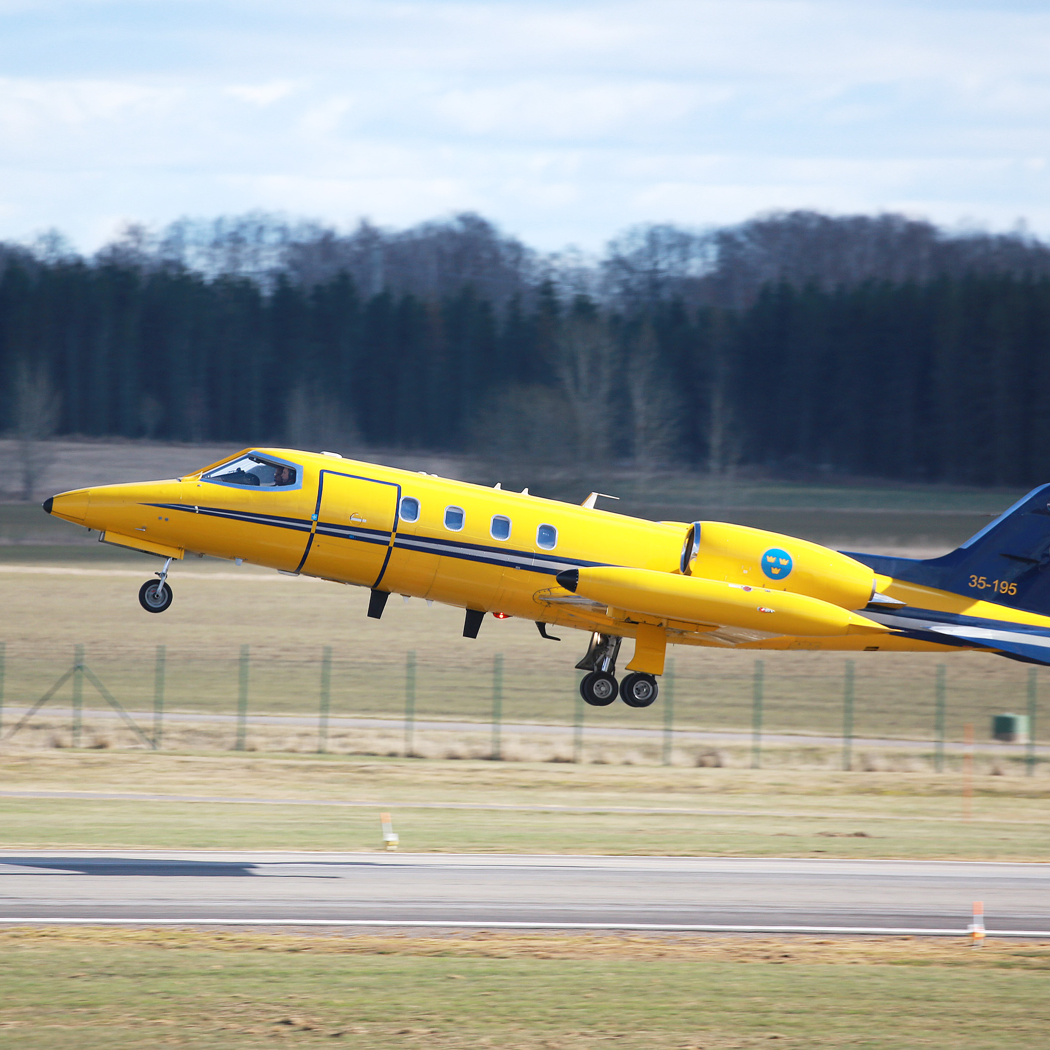 Gult flygplan lyfter från startbana