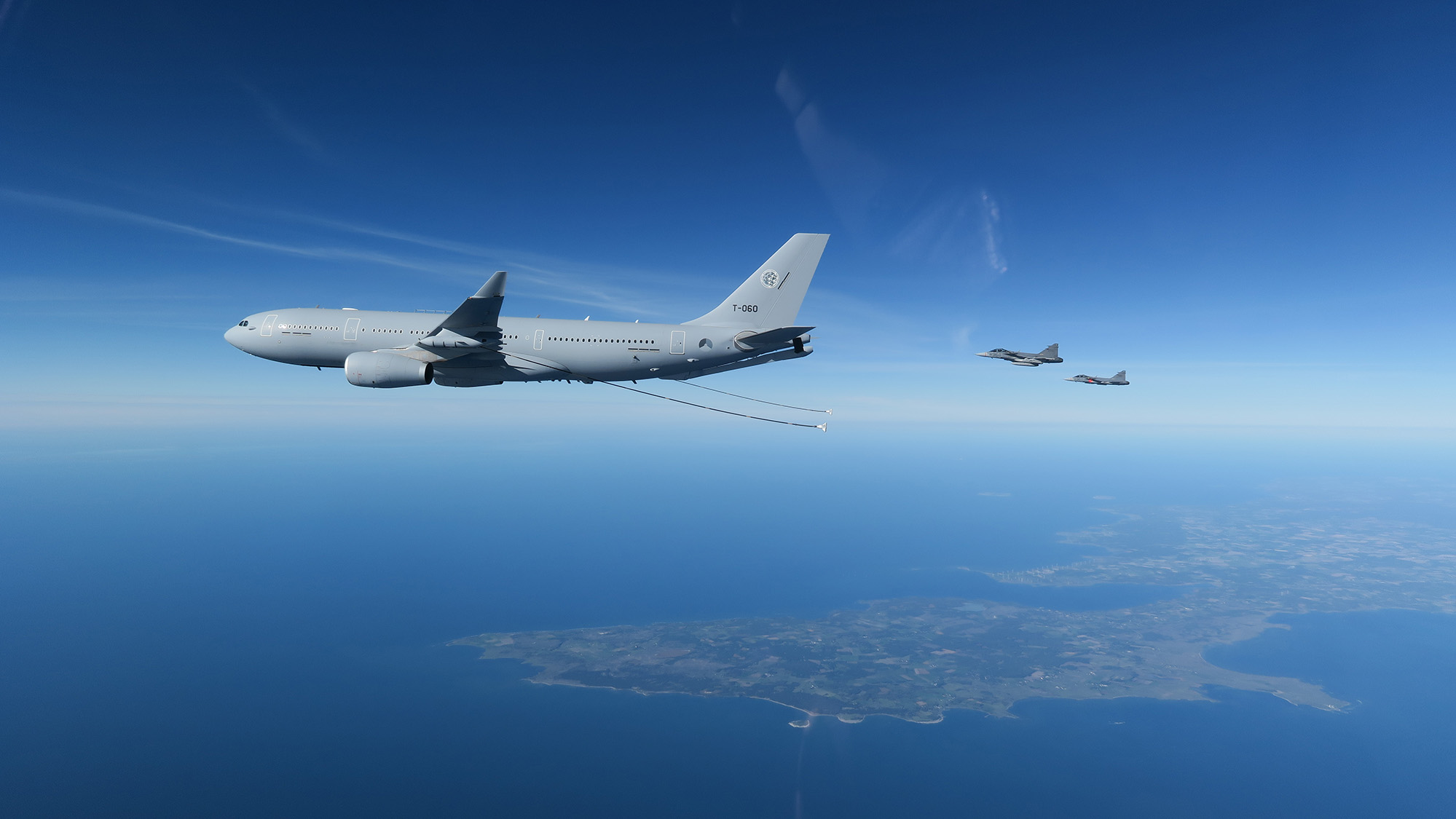 Bilden visar Natos flygplan A330 MRTT med två slangar för lufttankning som hänger efter planet, samt två JAS 39 C/D som flyger bakom.