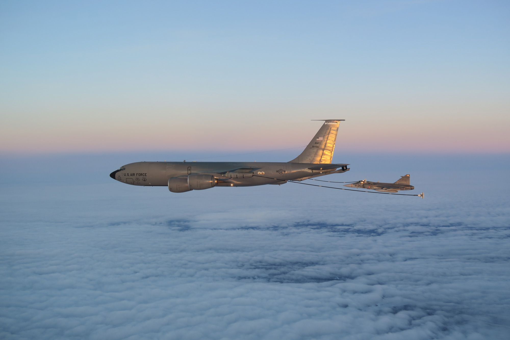 Två flygplan som genomför lufttankning i mörker, det amerikanska flygvapnets tankerflygplan Boeing KC135 Stratotanker och JAS 39 c/d.
