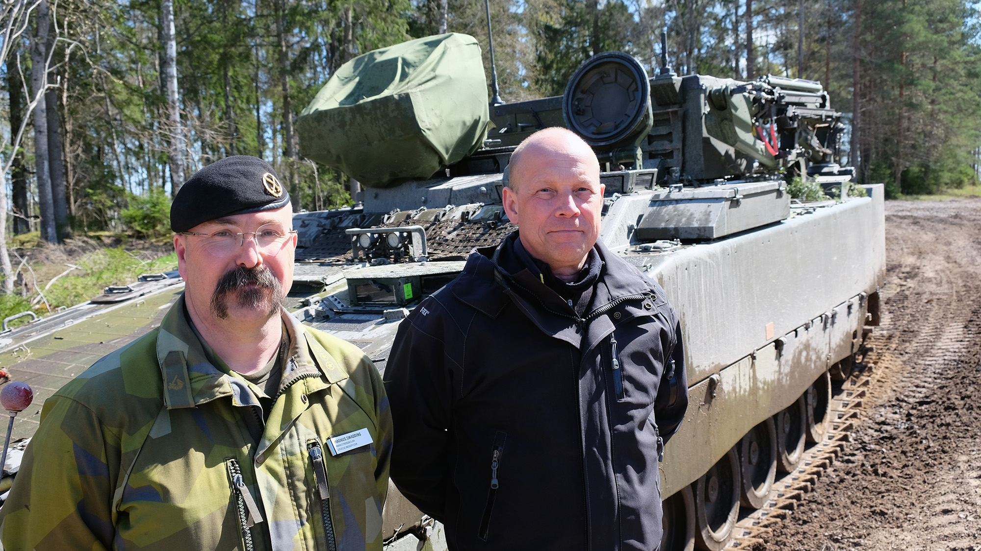 Magnus Swadding, Försvarsmakten, och Daniel Ekdahl, FMV, står framför prototypen av Pionjärpansarbandvagnen, som nu testas.