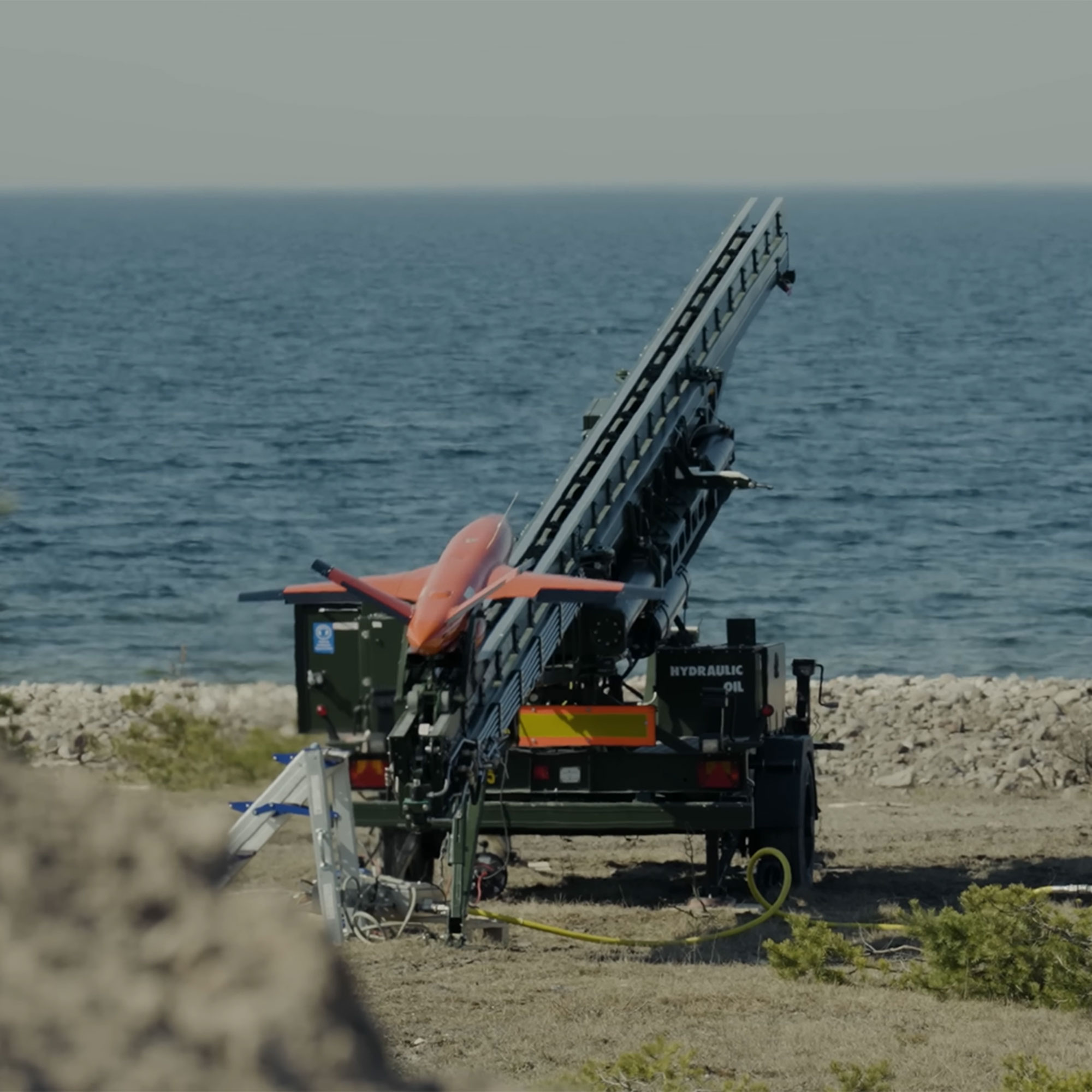 Orange målrobot avfyras från ramp och skjuts ut över havet.