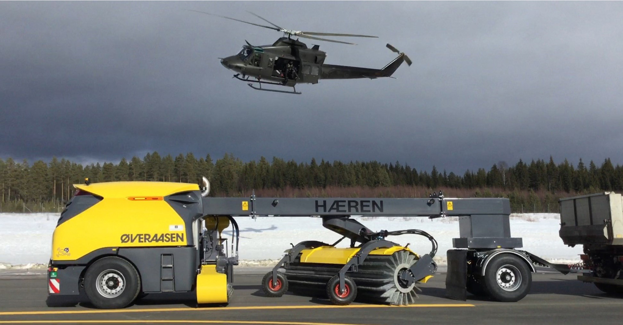 En sop- och blåsmaskinen av produktionstyp RS 200 med en helikopter som flyger ovanför.  