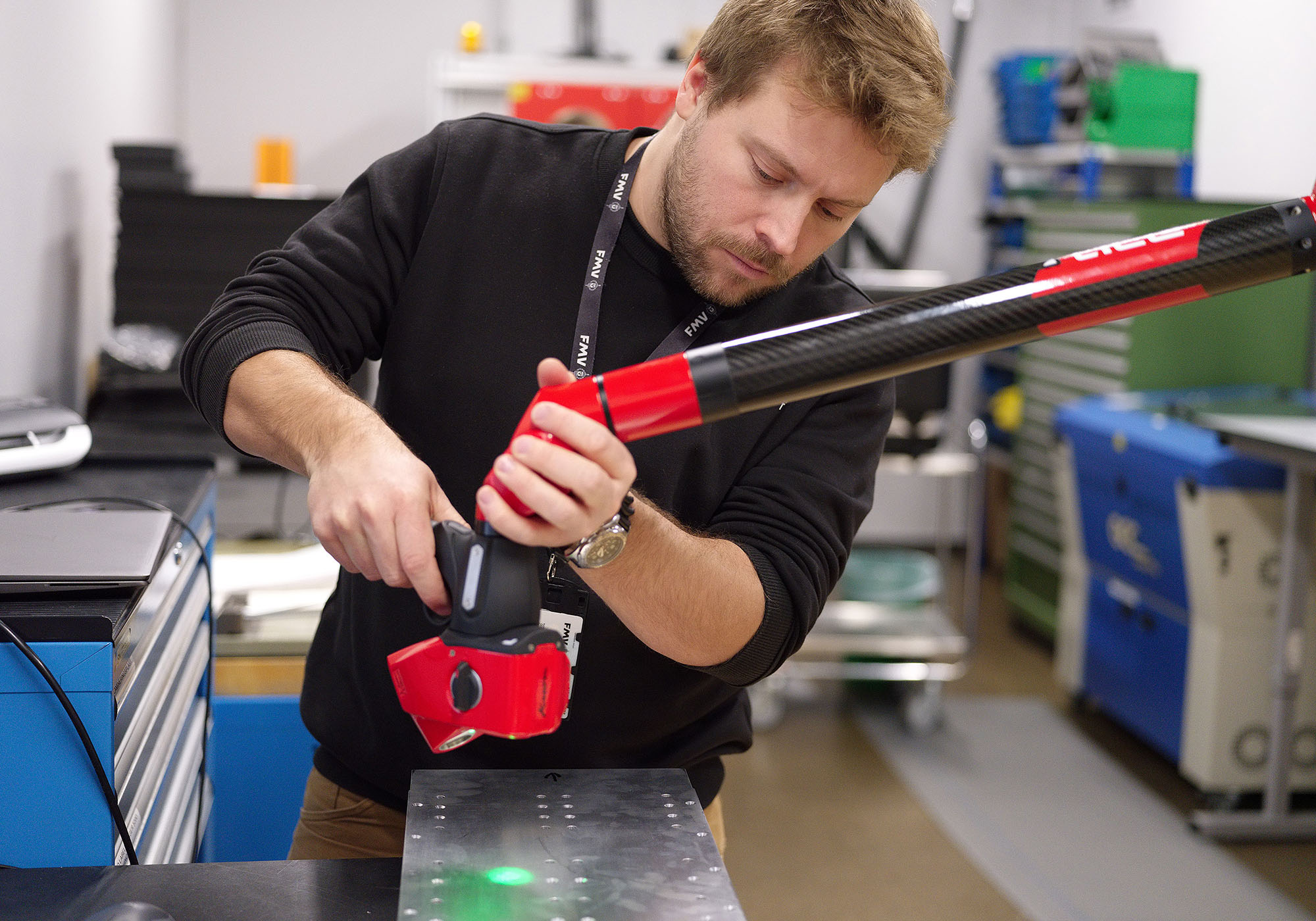 Calle Nordenhed, produktionstekniker, scannar en lastbärare till en kapsel, som ska hängas under vingen på flygplanet LR60, för att hitta eventuella avvikelser. 3D-scannern går över hela ytan och stämmer av alla mätpunkter.
– Jag kollar så att det inte finns några större avvikelser på lastbäraren, ser så att den är helt rak och att den uppfyller alla krav, säger han. Foto: Karl-Kristofer Sjöström/FMV