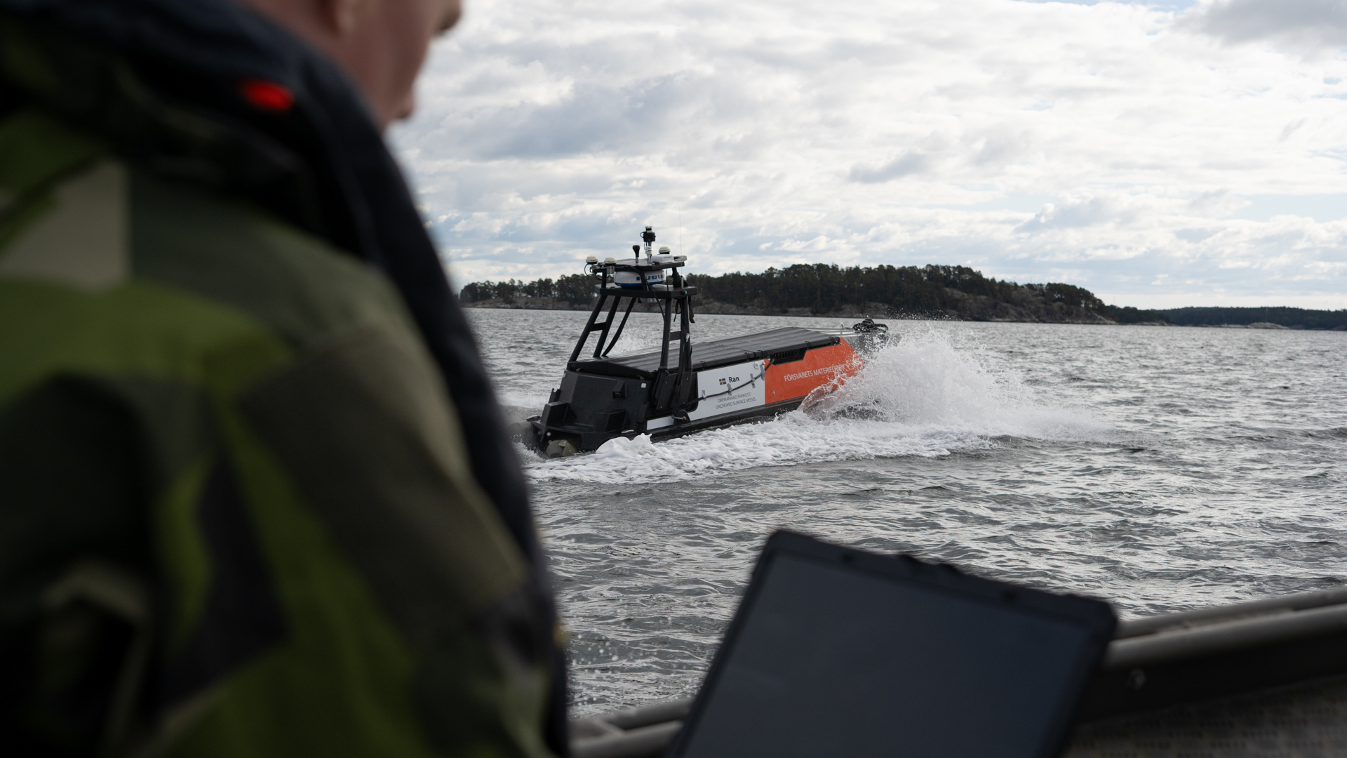 Under proven fjärrstyrs och övervakas den obemannade båten av en pilot ombord på en gruppbåt. Foto: FMV