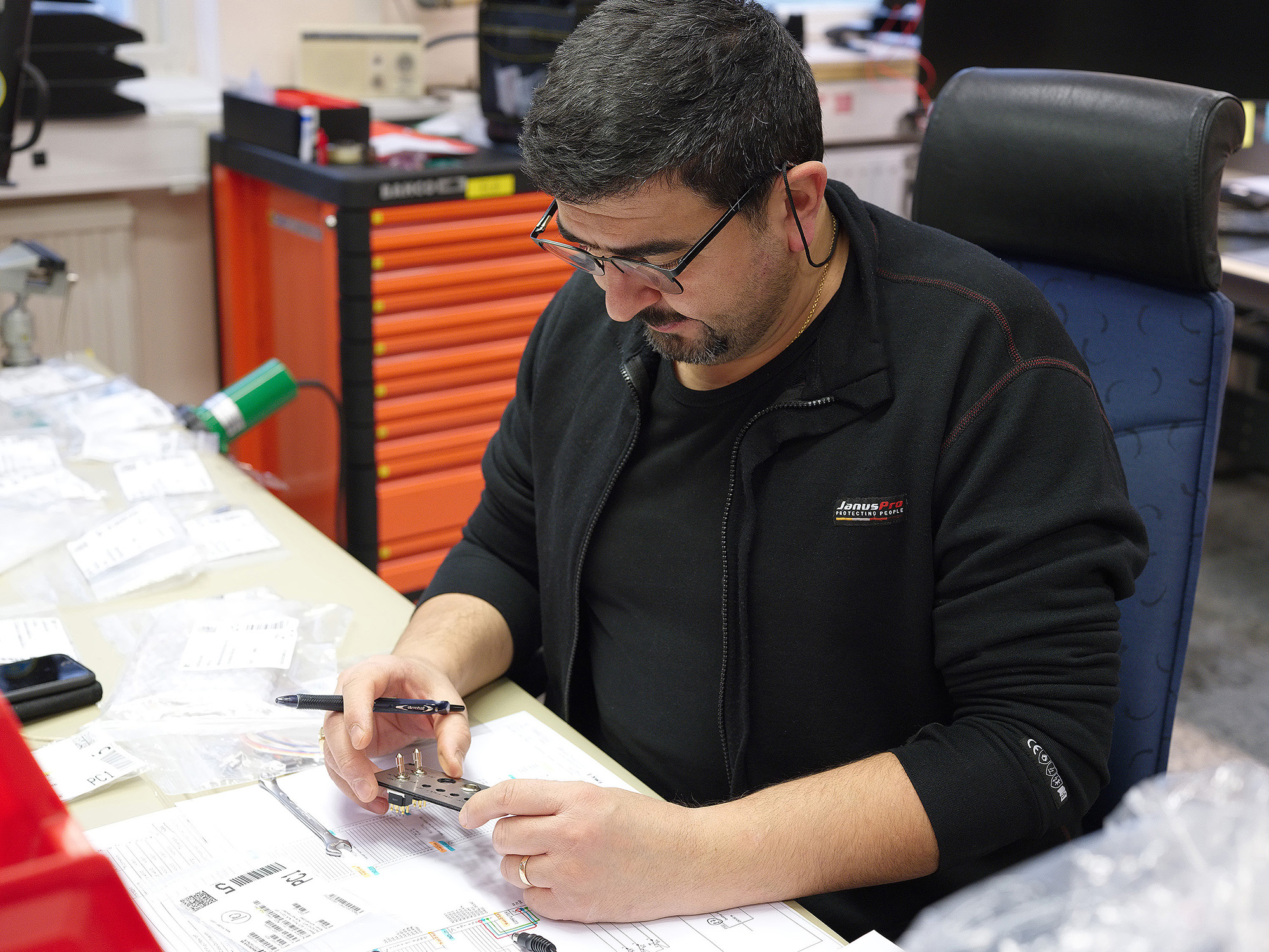 Walid Zomia, eltekniker. Han får ett schema över hur installationen i flygplan och helikoptrar ska se ut och ser bland annat till att man har allt material och att det följer standard. Foto: Karl-Kristofer Sjöström/FMV