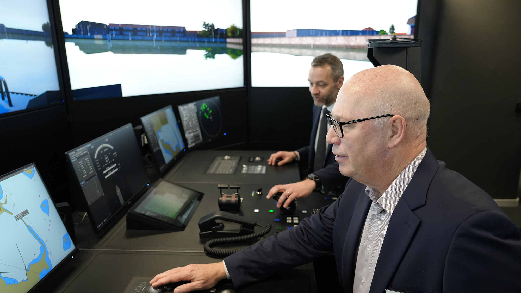 Två män kör ett fartyg i simulatorbryggan. 